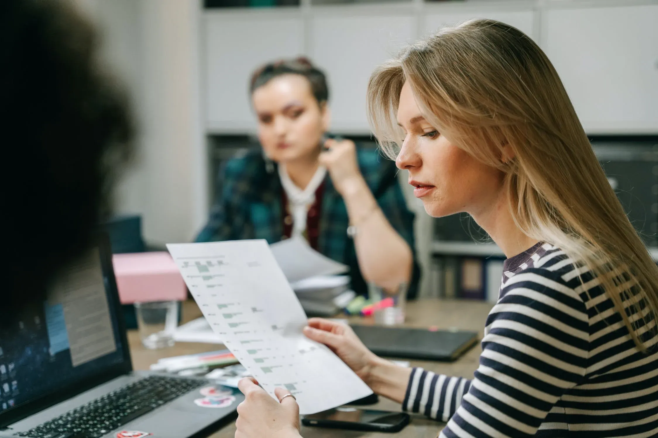 Woman lookin up graphs on paper